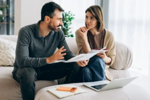 Couple discussing finances highlighting debt impact on relationships and well-being - Northeast Alabama