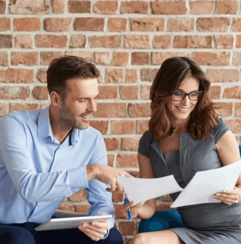 Smiling couple meeting with a Northeast Alabama bankruptcy attorney to discuss Chapter 7 and Chapter 13 debt relief options